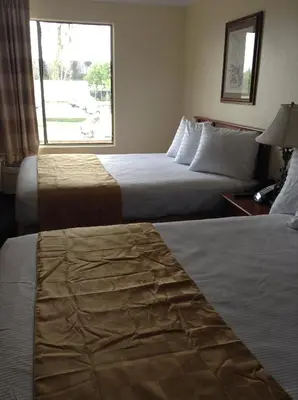 a hotel room with two beds and a window at Best Inn & Suites in Anaheim