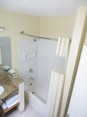 a white bathroom with a tub and a shower at Best Inn & Suites in Anaheim