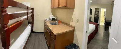 a small kitchen with a sink and a bed at Best Inn & Suites in Anaheim