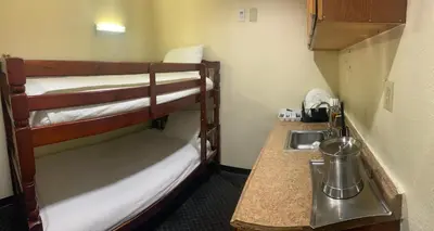 a small room with two bunk beds and a sink at Best Inn & Suites in Anaheim