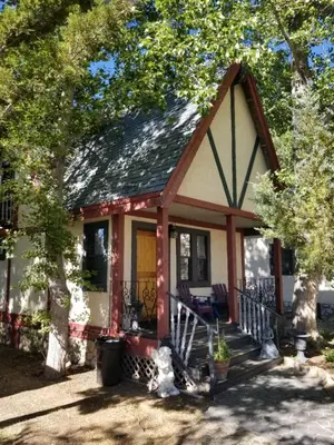 a small red and white house with a porch at Castle Wood Theme Cottages- COUPLES ONLY in Big Bear Lake