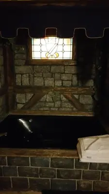 a stained glass window on top of a brick wall at Castle Wood Theme Cottages- COUPLES ONLY in Big Bear Lake