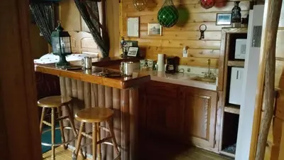a kitchen with a counter and stools in a cabin at Castle Wood Theme Cottages- COUPLES ONLY in Big Bear Lake