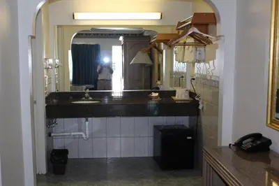 a bathroom with a sink and a person in a mirror at Best Whittier Inn in Whittier