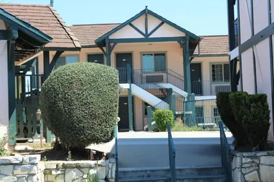 a house with a large bush in front of it at Best Whittier Inn in Whittier
