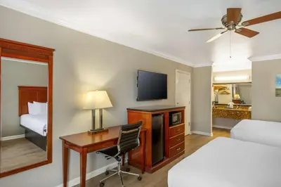 a hotel room with a desk and a bed and a television at Best Western Heritage Inn in Bakersfield