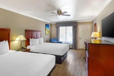 a hotel room with two beds and a flat screen tv at Best Western Heritage Inn in Bakersfield