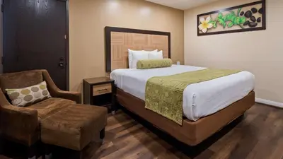 a bedroom with a large bed and a chair at Best Western Plus Glendale in Glendale