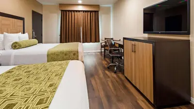 a hotel room with two beds and a flat screen tv at Best Western Plus Glendale in Glendale
