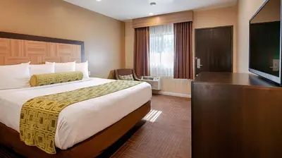 a hotel room with a bed and a flat screen tv at Best Western Plus Glendale in Glendale