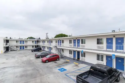 a large white building with cars parked in a parking lot at Motel 6-Long Beach, CA - International City in Long Beach