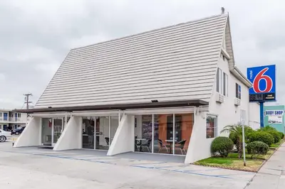 a building with a gray roof on a street at Motel 6-Long Beach, CA - International City in Long Beach