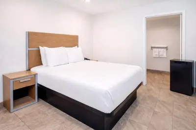 a bedroom with a large bed and a night stand at Super 8 by Wyndham Bakersfield CA in Bakersfield