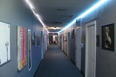 a hallway with blue walls and a long hallway with a hallway at Artist Housing - Downtown in Los Angeles