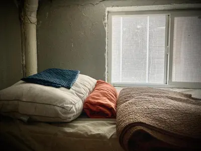 an unmade bed in a room with a window at Artist Housing - Downtown in Los Angeles