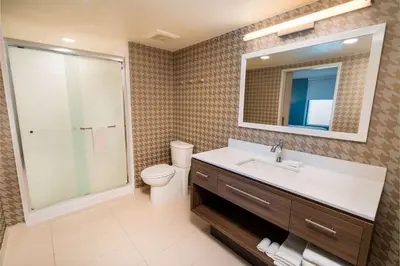 a bathroom with a sink and a toilet and a mirror at Home2 Suites Bakersfield in Bakersfield