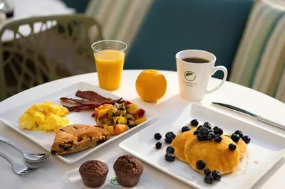 a table with two plates of breakfast food and a cup of orange juice at Element Anaheim Resort Convention Center in Anaheim
