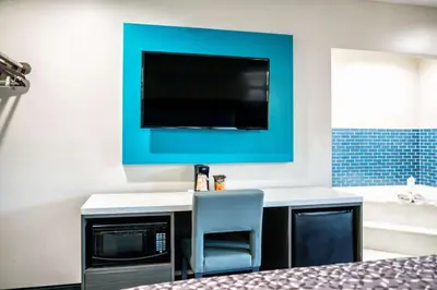 a room with a desk with a chair and a tv at Rodeway Inn South Gate - Los Angeles South in South Gate