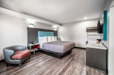 a hotel room with a bed and a chair at Rodeway Inn South Gate - Los Angeles South in South Gate