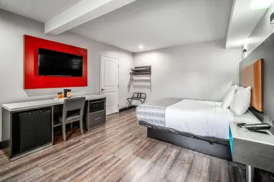 a hotel room with a bed and a desk and a tv at Rodeway Inn South Gate - Los Angeles South in South Gate