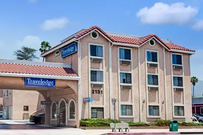 a building with a sign for a hotel at Travelodge by Wyndham Pasadena Central in Pasadena
