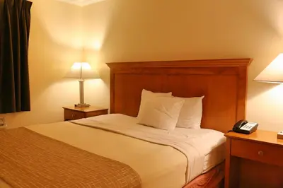 a hotel room with a bed and a telephone at Travelodge by Wyndham Pasadena Central in Pasadena