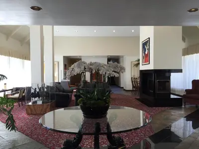 a lobby with a table with a vase of flowers on it at Mikado Hotel in North Hollywood