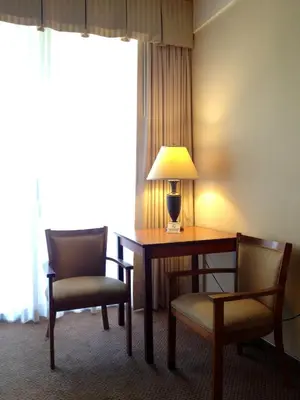 a hotel room with a desk and two chairs and a lamp at Mikado Hotel in North Hollywood