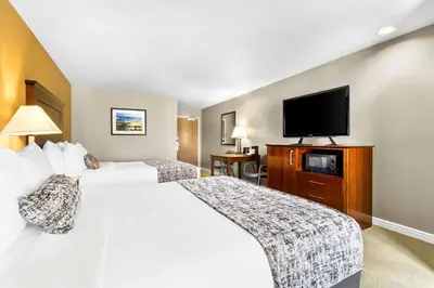 a hotel room with two beds and a flat screen tv at Best Western California City Inn & Suites in California City