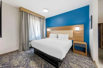 a bedroom with a large bed and a blue wall at Executive Residency by Best Western Victorville in Victorville