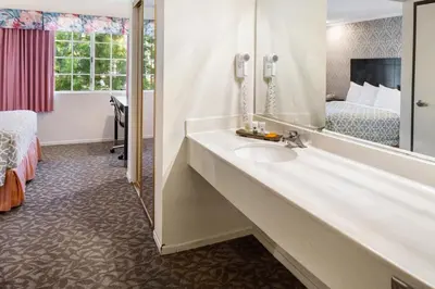 a bathroom with a sink and a bed and a mirror at Glendale Hotel in Glendale