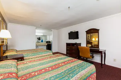 a hotel room with two beds and a desk at Buena Vista Inn in Anaheim