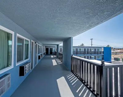 a balcony of a building with blue walls and windows at Motel 6 Ridgecrest, CA China Lake in Ridgecrest