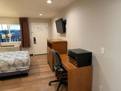 a room with a desk with a television and a bed at Motel 6 Ridgecrest, CA China Lake in Ridgecrest