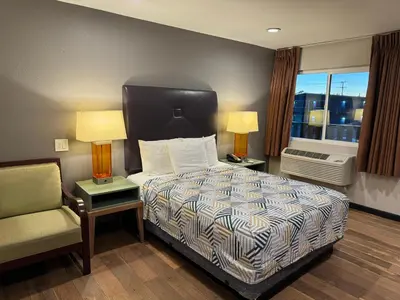 a bedroom with a bed and a chair and a window at Motel 6 Ridgecrest, CA China Lake in Ridgecrest