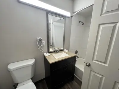 a bathroom with a toilet and a sink and a mirror at Motel 6 Ridgecrest, CA China Lake in Ridgecrest