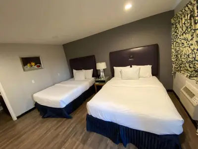 a hotel room with two beds with white sheets at Motel 6 Ridgecrest, CA China Lake in Ridgecrest