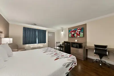 a hotel room with a bed and a desk at Red Roof Inn Los Angeles - Bellflower in Bellflower