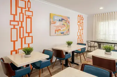 a dining room with two tables and chairs at The Sojourn Los Angeles - Sherman Oaks in Sherman Oaks