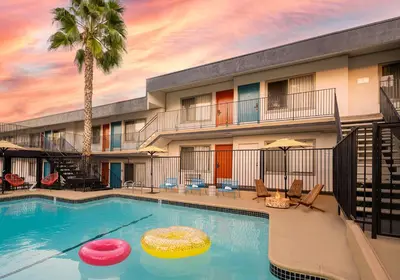 a pool at a hotel with a palm tree and two frisbees at The Sojourn Los Angeles - Sherman Oaks in Sherman Oaks