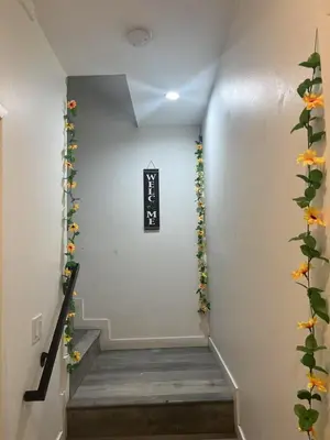 a stairway with flowers and a sign on the wall at Modern Hostel address changed in Los Angeles