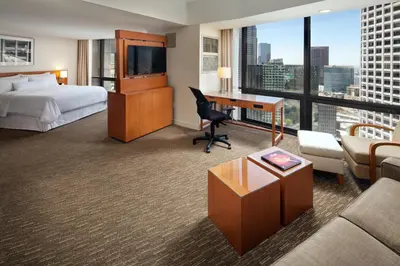 a hotel room with a bed and a desk with a computer at The Westin Bonaventure Hotel & Suites, Los Angeles in Los Angeles