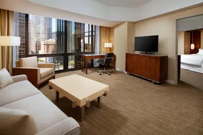 a hotel room with a couch and a bed and a television at The Westin Bonaventure Hotel & Suites, Los Angeles in Los Angeles
