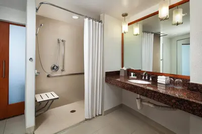 a bathroom with a shower and a sink and a mirror at The Westin Bonaventure Hotel & Suites, Los Angeles in Los Angeles