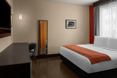 a bedroom with a bed and a desk and a window at SIRTAJ – Beverly Hills in Los Angeles