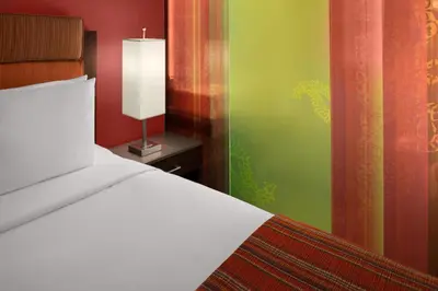 a bedroom with a bed and a lamp on a table at SIRTAJ – Beverly Hills in Los Angeles