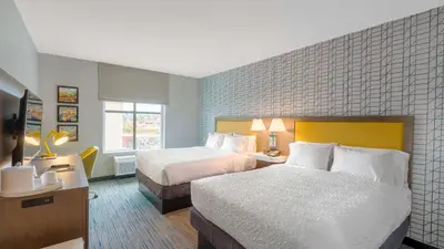 a hotel room with two beds and a television at Hampton Inn Riverside Downtown in Riverside