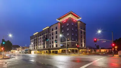 a building with a sign on top of it at night at Hampton Inn Riverside Downtown in Riverside
