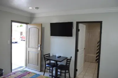 a dining room with a table and chairs and a television at El Rey Inn - LAX in Gardena