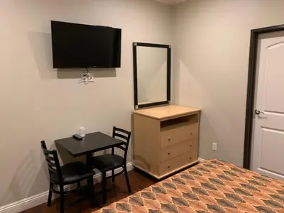 a bedroom with a bed and a table and a mirror at El Rey Inn - LAX in Gardena